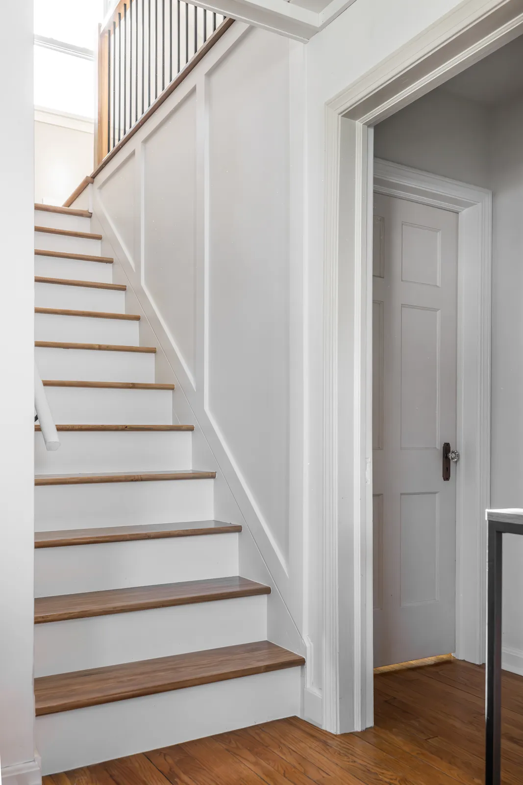 Finished staircase with custom oak treads and wainscoting